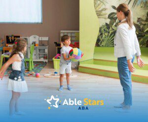 ABA therapist and two kids playing with a ball.