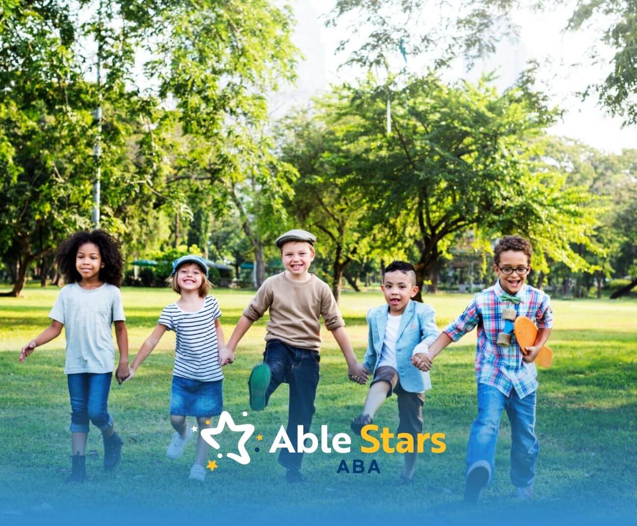 A group of children holding hands and walking together through a park.