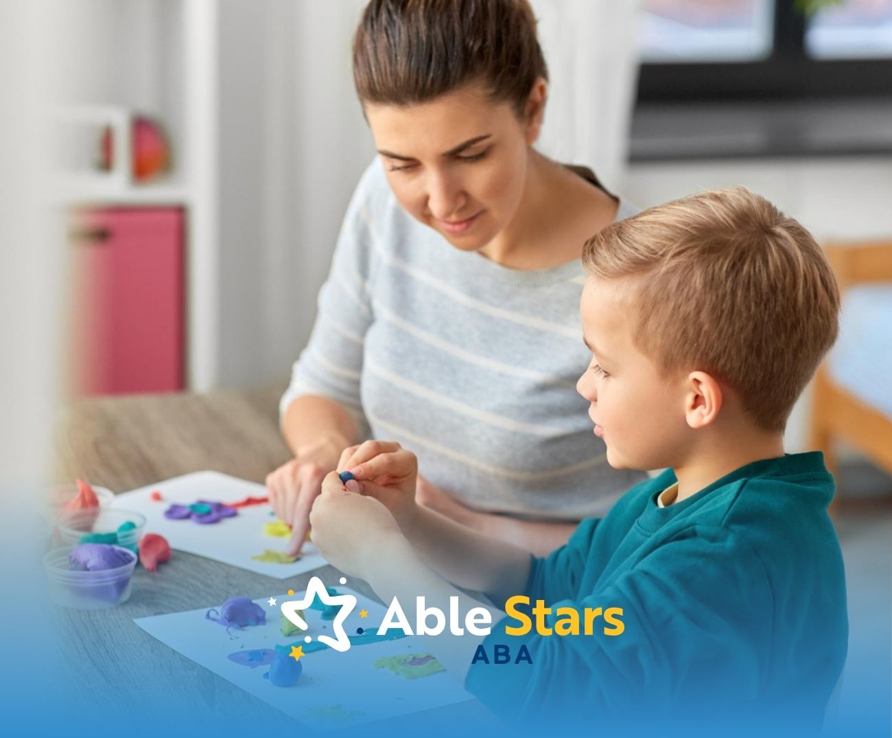 BCBA and autistic boy playing with colorful modeling clay at a table.