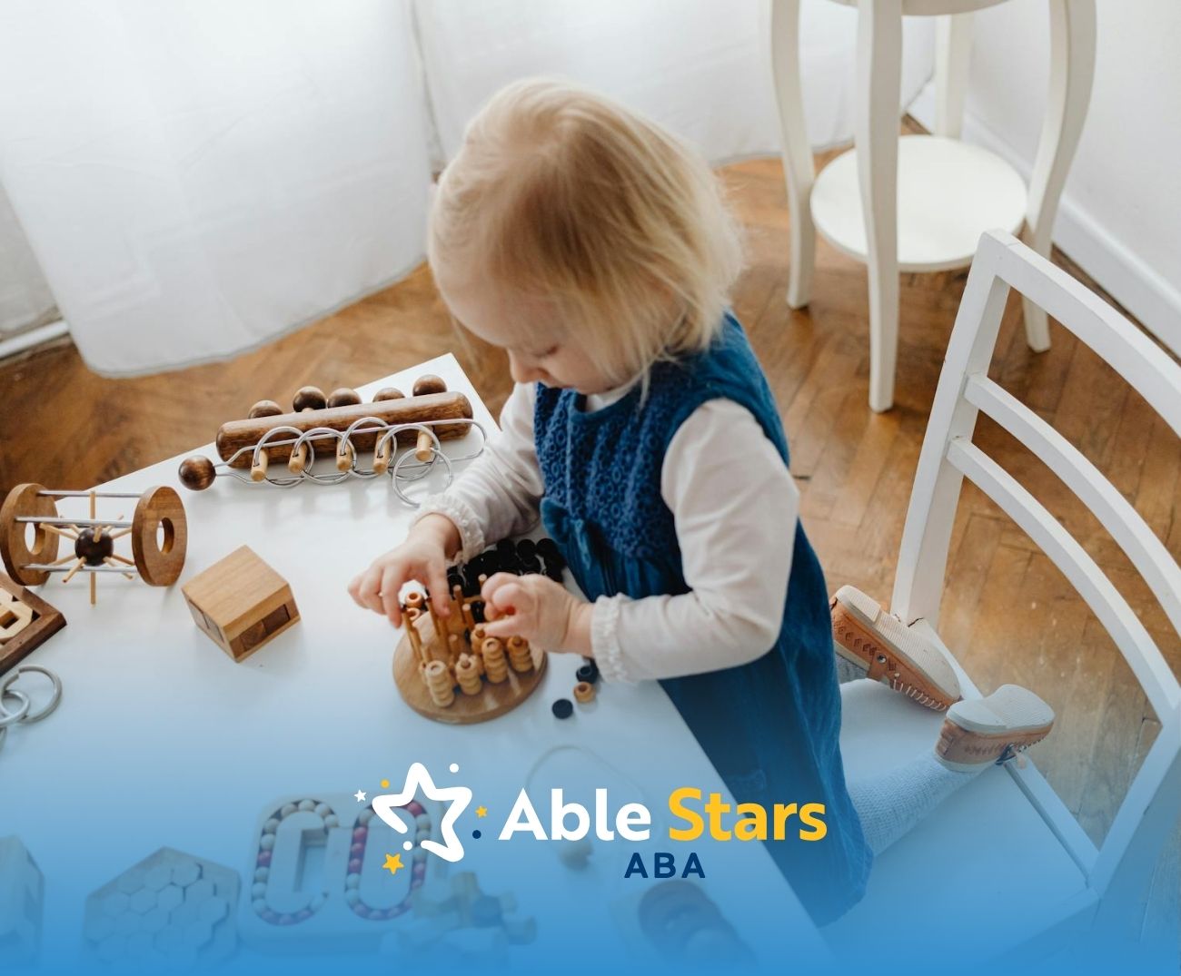 Toddler girl playing with wooden educational toys at a white table