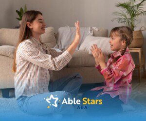 ABA therapist and autistic girl playing hand-clapping games in a cozy indoor setting.