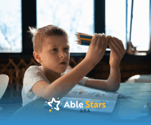 A boy with autism holding colored pencils