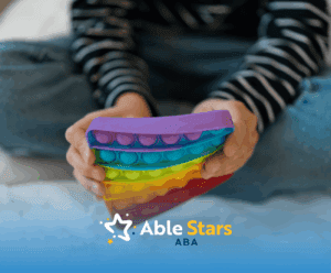 A child in a spectrum playing with a rainbow-colored fidget toy