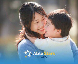 A woman and child share a joyful embrace, both smiling brightly. The background is softly blurred.