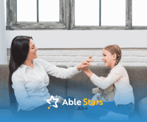 A girl with autism high-fiving her ABA therapist during their ABA therapy session