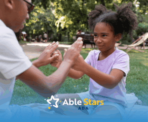 A child with autism high-fiving her ABA therapist during their ABA therapy session outdoors