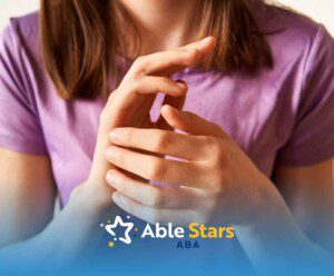 A person in a purple shirt rubbing their hands together, conveying focus.