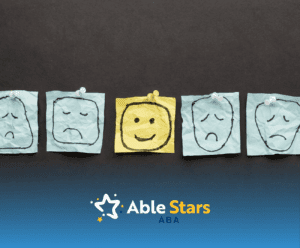 Five sticky notes with faces drawn on it: Four sad faces and one happy face