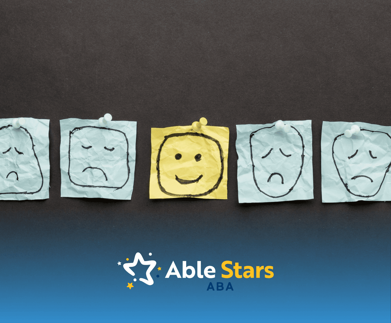 Five sticky notes with faces drawn on it: Four sad faces and one happy face