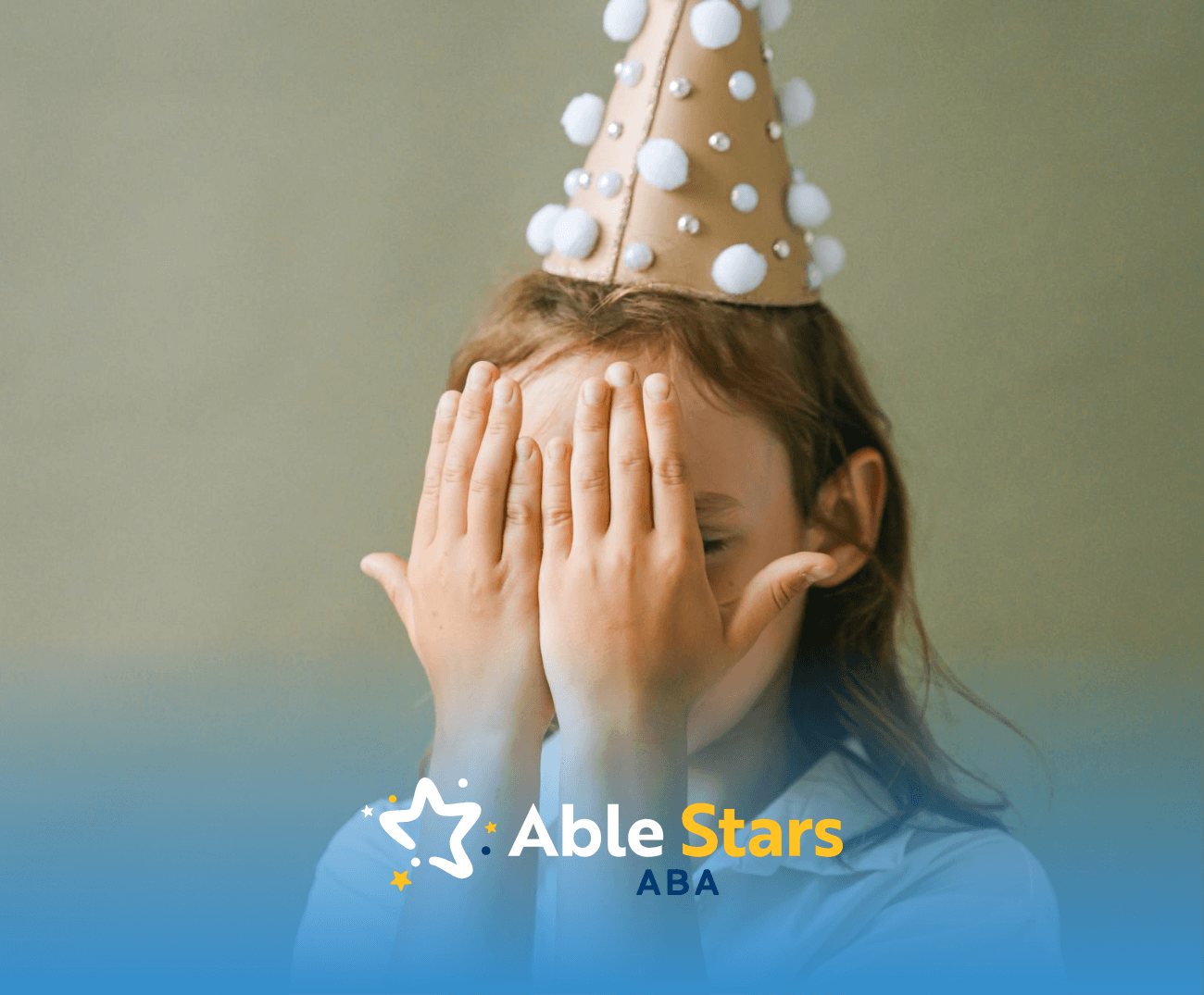Young autistic girl covering her face with hands, wearing a party hat, avoiding eye contact in Maryland.