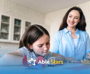 A BCBA watching an autistic girl fold paper in ABA therapy.