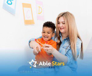 BCBA helping young boy play with a xylophone in a bright classroom setting during ABA therapy.