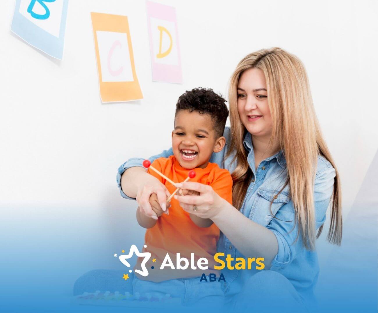 BCBA helping young boy play with a xylophone in a bright classroom setting during ABA therapy.