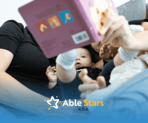 An ABA therapist and autistic child holding a book, with baby reaching out and looking up during ABA therapy in MD.