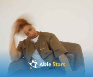 A person in motion sits in an armchair, head slightly blurred, suggesting movement.