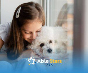 A girl with autism hugging a white fluffy dog by a window.