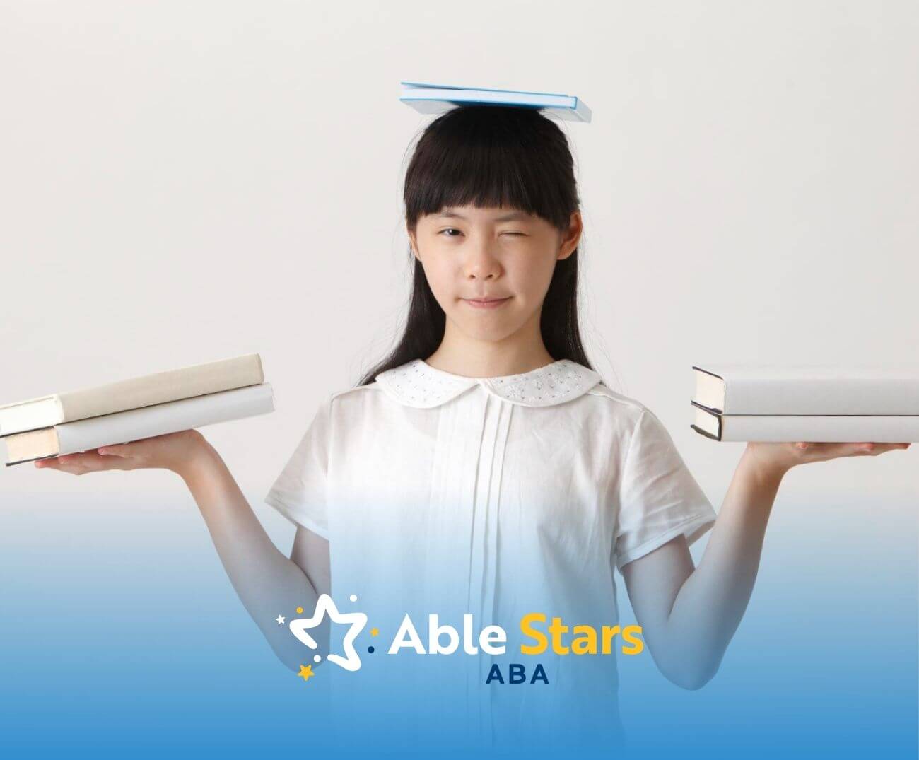 A girl with autism balancing books on her head and in her hands.
