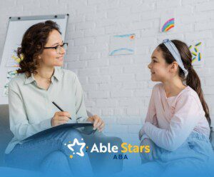 Child smiling and talking with BCBA during ABA therapy session in a bright room.