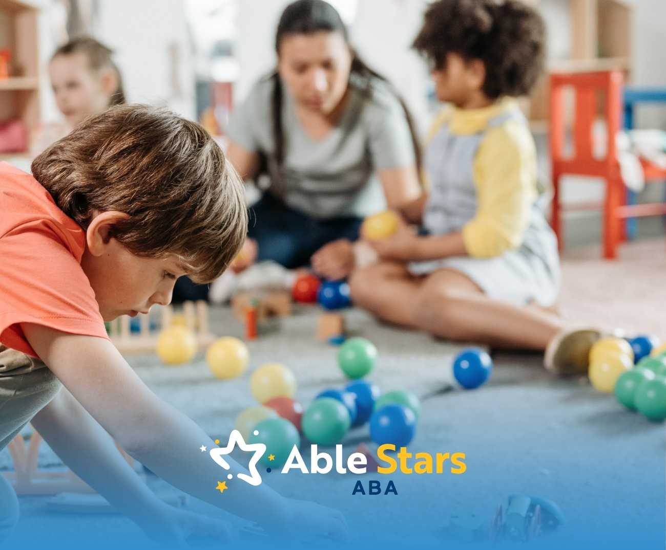 Young children engaged in play on a carpet with colorful balls, supervised by an adult.