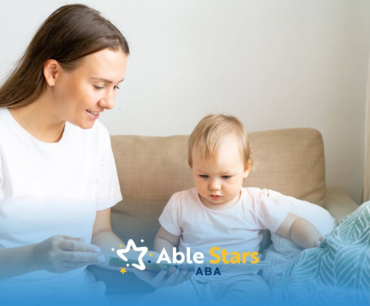 BCBA reads book with small child on couch during ABA therapy.