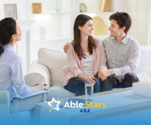 Couple talks with ABA therapist on couch during ABA parent training.