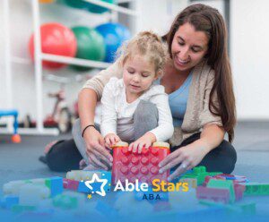 A woman and a young girl play with colorful building blocks on a carpeted floor. They smile, creating a warm and encouraging atmosphere.