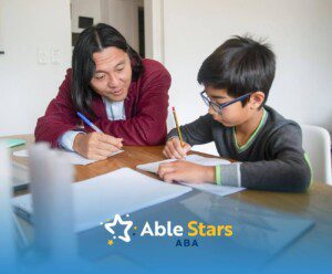 An autistic child sits at desk drawing with crayons while teacher gently guides, encouraging creativity and focused learning.