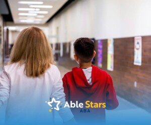 Two individuals stroll through a hallway lined with posters and wood-paneled walls, engaged in quiet conversation.