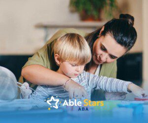 BCBA helping a young boy with autism use a cookie cutter while baking.