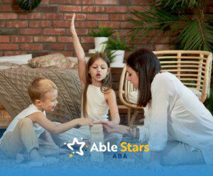 A BCBA and two children with autism playing a wooden block stacking game on the floor during ABA therapy.