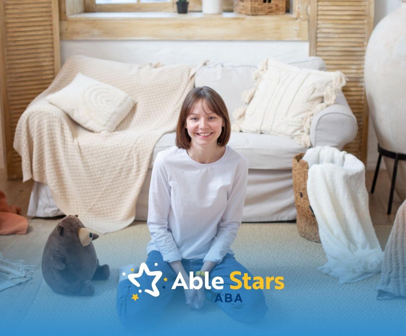 Smiling young girl with autism sitting on the floor in a cozy living room with stuffed toys.
