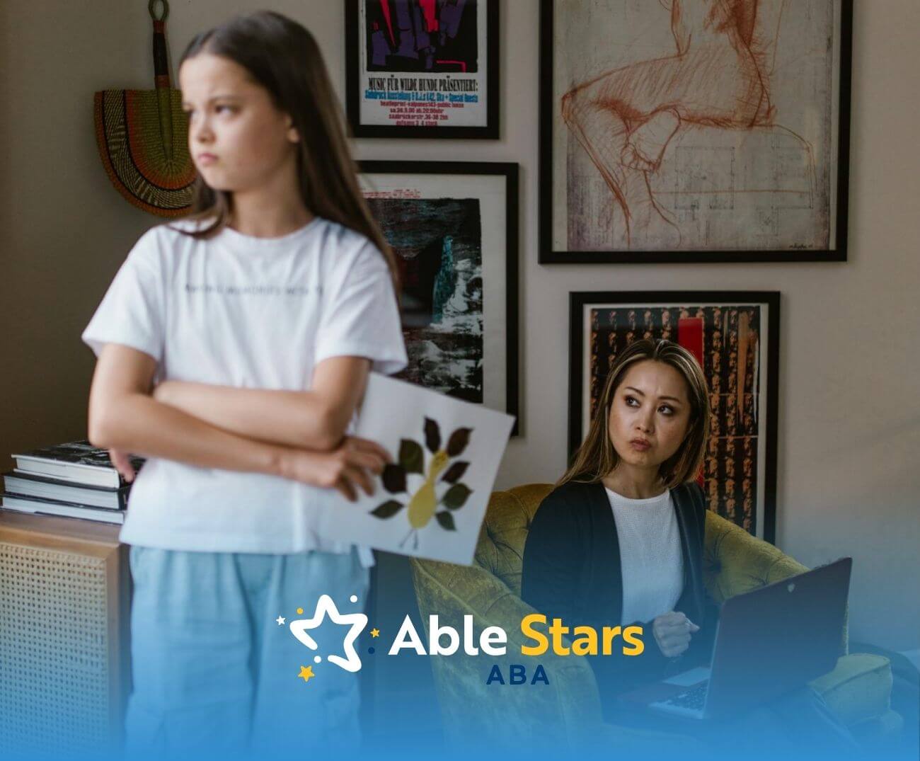 A young girl stands proudly with arms crossed, holding her leaf drawing, showing confidence and artistic joy.