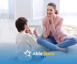ABA therapist using a mirror to help a child practice facial expressions during an ABA therapy session.