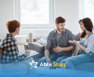 Parents talking with an ABA therapist during a parent training session.
